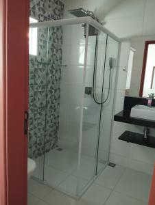 a glass shower in a bathroom with a sink at Aconchego nas Montanhas in São Thomé das Letras