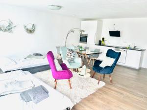 sala de estar con sillas rosas y azules y cama en Eifeltraum, en Blankenheim