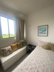 a bedroom with a bed and a window with pillows at Apartamento em frente ao Laguinho in Salinópolis