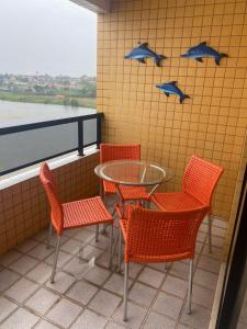 a table and chairs with a table and blue birds on the wall at Apartamento em frente ao Laguinho in Salinópolis
