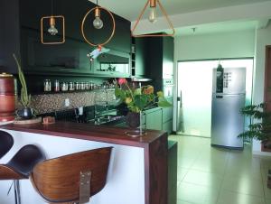a kitchen with green cabinets and a wooden counter at Aconchego nas Montanhas in São Thomé das Letras