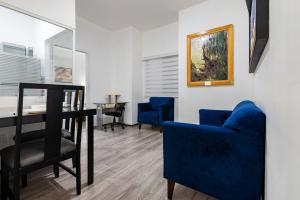 sala de estar con mesa y sillas azules en European Life Style Executive Suites, en Guadalajara