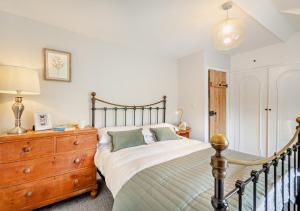 a bedroom with a bed and a wooden dresser at Tan Yr Orsedd in Abersoch