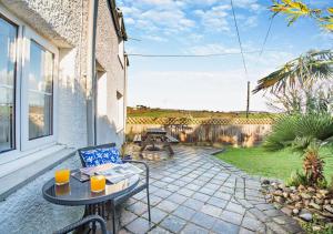 a patio with a table and chairs and a view at Tan Yr Orsedd in Abersoch