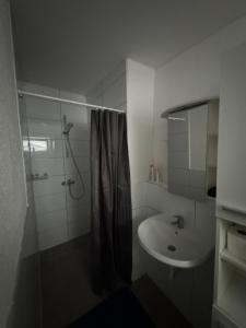 a white bathroom with a shower and a sink at Moderne Wohnung in Spaichingen in Spaichingen