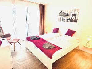 Un dormitorio con una cama blanca con una manta roja. en Eifeltraum, en Blankenheim
