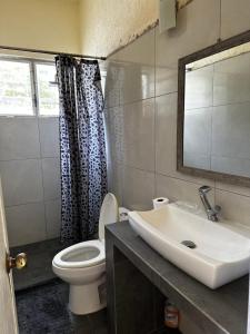 y baño con lavabo, aseo y espejo. en Hostal San Pablo, en Manzanillo