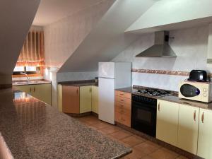 a kitchen with white cabinets and a stove top oven at Chalet As Mimosas in Cangas de Morrazo