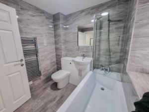 een badkamer met een toilet, een wastafel en een douche bij Elegant City Apt: 1-BR Luxury in Wolverhampton
