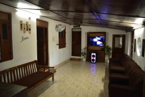 ein Wohnzimmer mit Sofas und einem TV im Zimmer in der Unterkunft IKIAM- in Nature's Embrace in Mānantoddy