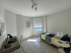 1 dormitorio con cama, mesa y escritorio en Un lujoso duplex en Radazul en primera linea de playa y con parking propio, en Radazul