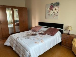 a bedroom with a large bed with flowers on it at Chalet As Mimosas in Cangas de Morrazo