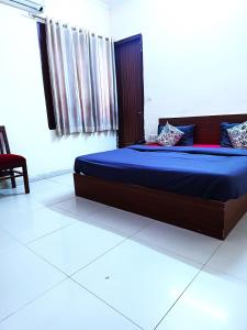 1 dormitorio con 1 cama grande con sábanas azules en Hotel S-14, en Jaipur