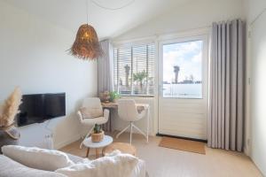 a living room with a window and a table with chairs at Yn 'e Haven Logies in Earnewâld