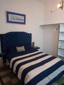 ein Schlafzimmer mit einem blau-weißen gestreiften Bett in der Unterkunft Casa Amparo, A media calle del zócalo Centro in Puebla