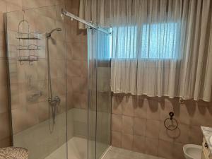 a bathroom with a shower with a glass door at Chalet As Mimosas in Cangas de Morrazo