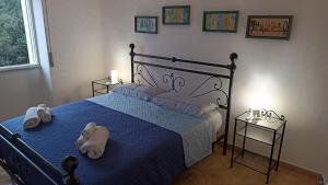 una camera da letto con un letto blu e asciugamani di Carloforte Appartamento con Vista IUN R2015 a Carloforte