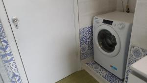 una lavatrice e asciugatrice in un piccolo bagno di Carloforte Appartamento con Vista IUN R2015 a Carloforte