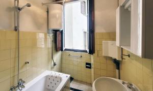 Taceno的住宿－La corte di via Chiarello，带浴缸、水槽和窗户的浴室