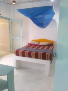 Cama en habitación con sombrilla azul en Piyo Vida Guesthouse en Ahangama