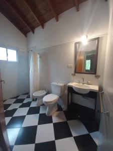 a bathroom with two toilets and a sink and a mirror at Tantanakuy 2 in Villa General Belgrano