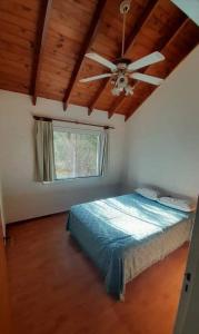 a bedroom with a ceiling fan and a bed at Tantanakuy 2 in Villa General Belgrano