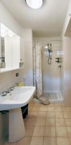 Taceno的住宿－La corte di via Chiarello，浴室配有白色水槽和淋浴。