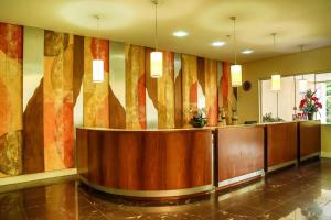 a lobby with a reception desk in a building at Hotel Le Village Distributed By Intercity in Joinville