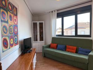 uma sala de estar com um sofá verde e uma televisão em Suite Rigel em Ponferrada