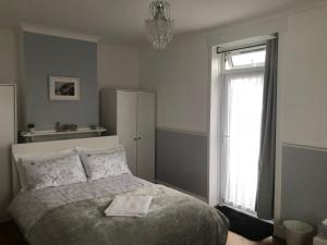 a bedroom with a bed with a towel on it at Butterfly Home in London