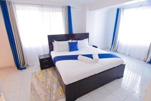 a bedroom with a large bed with blue accents at Visibly elegant in Kisumu