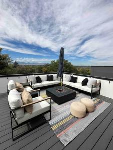 a patio with couches and a table on a deck at Spacious TH w/ Firepit, Mountain Views & Garage in Denver