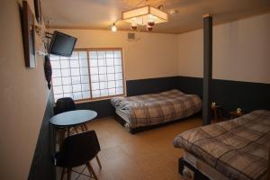 a room with two beds and a table and a tv at Otaro Village - Vacation STAY 63281v in Otaru