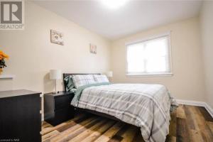 a white bedroom with a bed and a window at Cozy 3 Bedroom Downtown Hideaway Cottage with Complimentary Breakfast in Niagara Falls