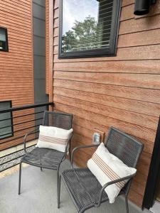 zwei Stühle auf einer Veranda neben einem Haus in der Unterkunft Spacious TH w/ Firepit, Mountain Views & Garage in Denver