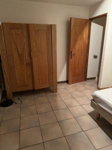 an empty room with wooden cabinets and a tiled floor at Le Bouffadou in Peisey-Nancroix