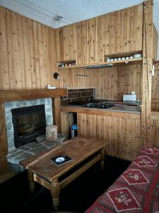 a kitchen with a stove and a table and a fireplace at Le Bouffadou in Peisey-Nancroix