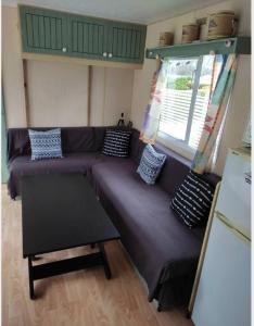 ein Wohnzimmer mit lila Sofas und einem Fenster in der Unterkunft Camping du Quinquis in Clohars-Carnoët