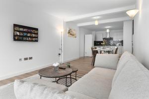 a living room with a couch and a table at 3 Bedroom Sleep12 in London MR2 in London +48 photos