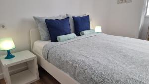 1 dormitorio con 1 cama grande con almohadas azules en Happen!ng, en Faro