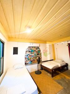 a room with two beds and a bench in it at Bella's Backpackers Cayo in San Ignacio