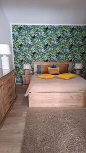 Dormitorio con cama grande y papel pintado colorido en Apartament u Janeczki, en Stepnica