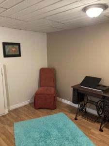 a room with a desk and a chair and a table at Executive Guest Suite in Edmundston