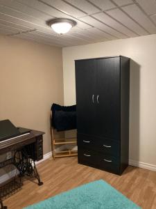 a large black cabinet in a room with a desk at Executive Guest Suite in Edmundston