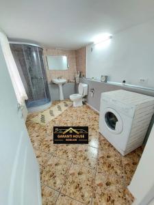 a bathroom with a washing machine and a toilet at House Bumba in Baia Mare