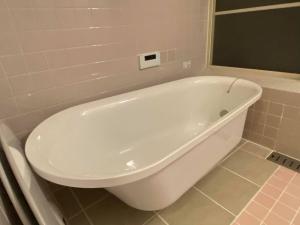 a white bath tub in a bathroom with a mirror at SlowTime - Vacation STAY 75364v in Shima