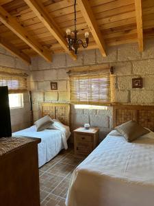 a bedroom with two beds and a stone wall at Cabañas Jassí in Querétaro