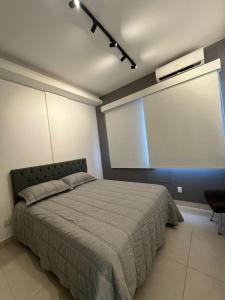 een slaapkamer met een bed en een groot raam bij Studio Sezerdelo in Rio de Janeiro