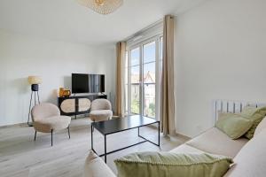 een woonkamer met een bank en stoelen en een tv bij La Résidence Alpha Viroflay 201 - 1 chambre - 4 pers in Viroflay
