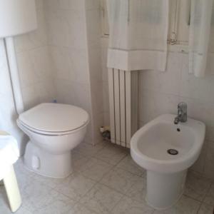 y baño blanco con aseo y bidet. en Hotel La Milanese, en Pietra Ligure